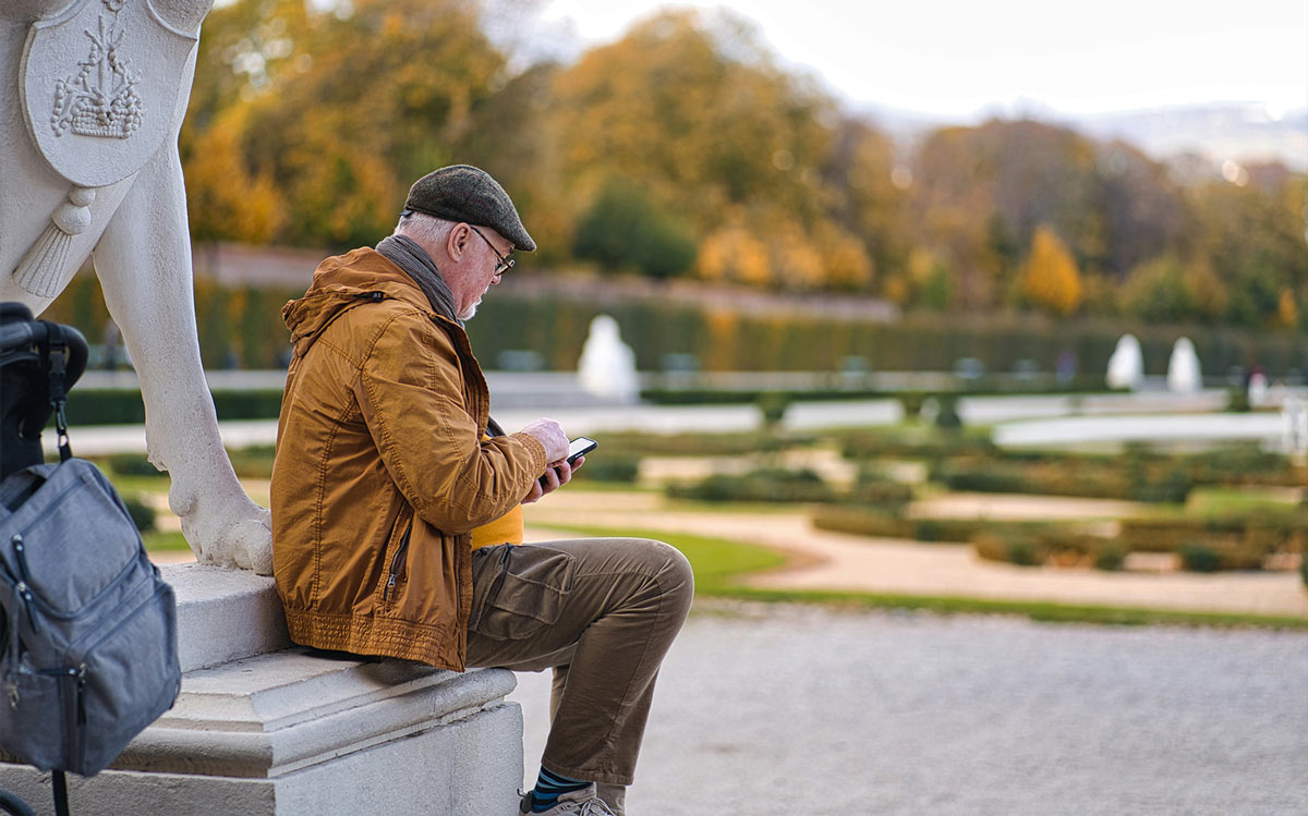 Senior man sitting and looking at phone